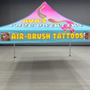 BRIGHTLY COLORED TENT WITH PAINT BRUSH AND PHOTOS SHOWING SAMPLES OF FACE PAINTING